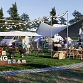 Scenic Camping Site With Tents RVs Outdoor Seating String Lights And Green Grass
