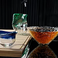 Colorful Beverage Glassware with Blue Rim Bowl Green Pitcher and Orange Liquid on Wooden Board