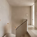 Minimalist Curved Staircase With White Walls Wall Lamps And Wooden Floor