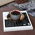 Beige Curved Sofa with Pillows Throw Blanket Round White Coffee Table and Black Table on Gray Rug