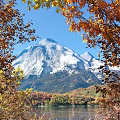 Garden Landscape With Snowy Mountain And Autumn Trees Under Clear Blue Sky