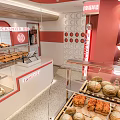 Family Dessert Shop Interior With Pink White Decor Display Cases And Fresh Bread
