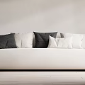 White Large Sofa With Black Striped And White Cushions Against Light Wall And Wooden Floor