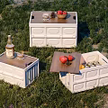 White Storage Boxes with Wooden Lids Holding Apples Bottles and Glasses on Grass