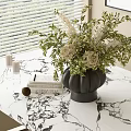 Black Vase With White Green Flowers On Marble Tabletop With Books And Candles