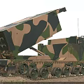 Military Camouflage Tank With Tracked Wheels And Rocket Launcher System In Desert Terrain