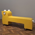 Yellow Animal Shaped Public Chair With Ears Eyes And Wheels On Wooden Floor