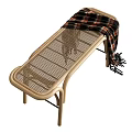 Light Wooden Footstool With Curved Frame Wicker Top And Draped Plaid Blanket