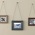 Three Framed Paintings Hanging On Light Colored Wall With Different Artworks
