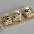 Delicious Layered Cream Cakes Topped With Chocolate Shavings On White Rectangular Tray