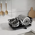 Black Dish Drying Rack With Stacked Plates And Wooden Utensils On Marble Kitchen Countertop
