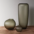 Ribbed Olive Green Glass Vases in Various Sizes on Wooden Table with Light Gray Wall