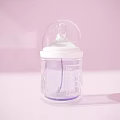 Transparent Baby Bottle With White Nipple Measurement Scale And Pink Background