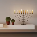 Elegant Candelabra With Lit Candles And Green Spherical Plants On White Shelf