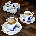 Lavazza Steaming Coffee Cups With Latte Art And Sachets On Wooden Table