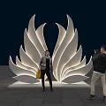 Large White Petal Shaped Illuminated Outdoor Sculpture With People Taking