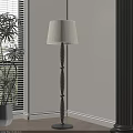 Cream Fabric Shade Floor Lamp With Black Textured Pole By Window And Green Plant