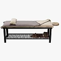 Massage Bed with Black Frame Gray Beige Blanket Pillows and Lower Shelf Stacked Towels