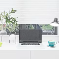 Modern Laptop on White Desk with Green Apples Plant Lamp and Blue Cup