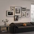 Stylish Photo Wall with Framed Black and White Pictures Above Dark Sofa and Green Plant