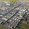 Aerial View Of Dense Residential Area With Neatly Arranged Houses And Green Grasslands