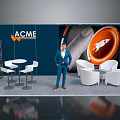 ACME Exhibition Booth Display With Blue Background Orange Accents White Furniture And Man