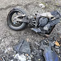 Burned Motorcycle Remains With Debris And Ash On Gravel Ground