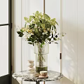 Glass Vase With Green Leaves And White Flowers On Table With Decorative Items