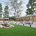 Outdoor Market Setup On Green Lawn With Canopies Booths String Lights And Fire Pit