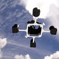 Flying Quadcopter Drone With Four Propellers And White Frame Against Blue Sky