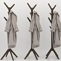 Light Gray Coats With White Cuffs Hanging On Three Wooden Coat Racks