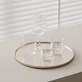 Clear Glass Cups On Round Gold Rim Tray With White Surface And Window Blinds