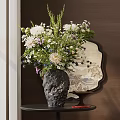 Black Textured Vase With White Purple Flowers On Dark Table Near Round Decorative Mirror