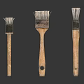 Three Old Brushes Of Various Sizes With Wooden Handles And Worn Bristles On White Background