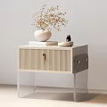 Light Beige Bedside Table With Vertical Slat Door Transparent Legs Stacked Books And White Vase