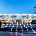 Modern Sales Office Building With Horizontal Striped Facade And Illuminated Steps Under Blue Sky