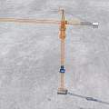 Tall Orange Tower Crane With Long Boom Standing On Construction Site Ground