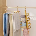 Gold Multi Hook Hanger Hanging Colorful Towels And Fabrics On Light Wall With Wooden Details