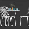 White Metal Outdoor Table With Intricate Cutout Chairs Orange Vase Blue Cups And Flower Decoration