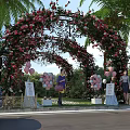 Iron Arbor Decorated With Pink Red Flowers Balloons Palm Trees And Greenery In Outdoor Setting