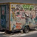 Graffiti Covered Mobile Trailer With Colorful Street Art And Weathered Surfaces Parked On Urban Street