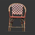 Red Wicker Chair With Patterned Backrest Curved Armrests And Metal Frame On Round Gray Mat