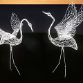 Illuminated Wire Crane Landscape Sculptures With Open Wings By Coastal Sunset Grassy Area