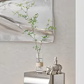 Transparent Vase With Green Branches Beige Band Near White Elephant Figurine Against Light Colored Wall
