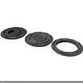 Three Black Circular Mechanical Components With Central Holes And Raised Edges