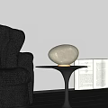 Oval Shaped Cream Colored Table Lamp with Gold Base on Black Table Near Leather Sofa