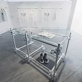 Modern Display Space With Glass Table Metal Frame Gray Shoes White Clothes