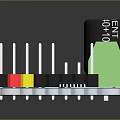 Blue Electronic Circuit Board With Black Capacitor Green Connector And Colored Pins