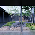 Tranquil Garden Landscape With Natural Rocks Small Trees Lush Shrubs And Dark Pillars