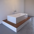 White Freestanding Bathtub On Platform Surrounded By Pebbles With Modern Faucet